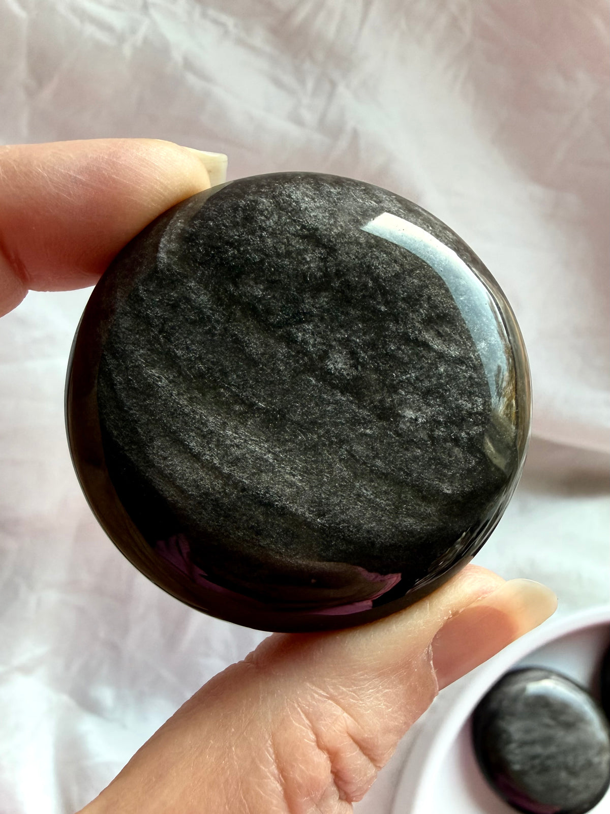 Silver Sheen Obsidian palm stone with flowing graphite bands and shimmering silver patterns against glossy black