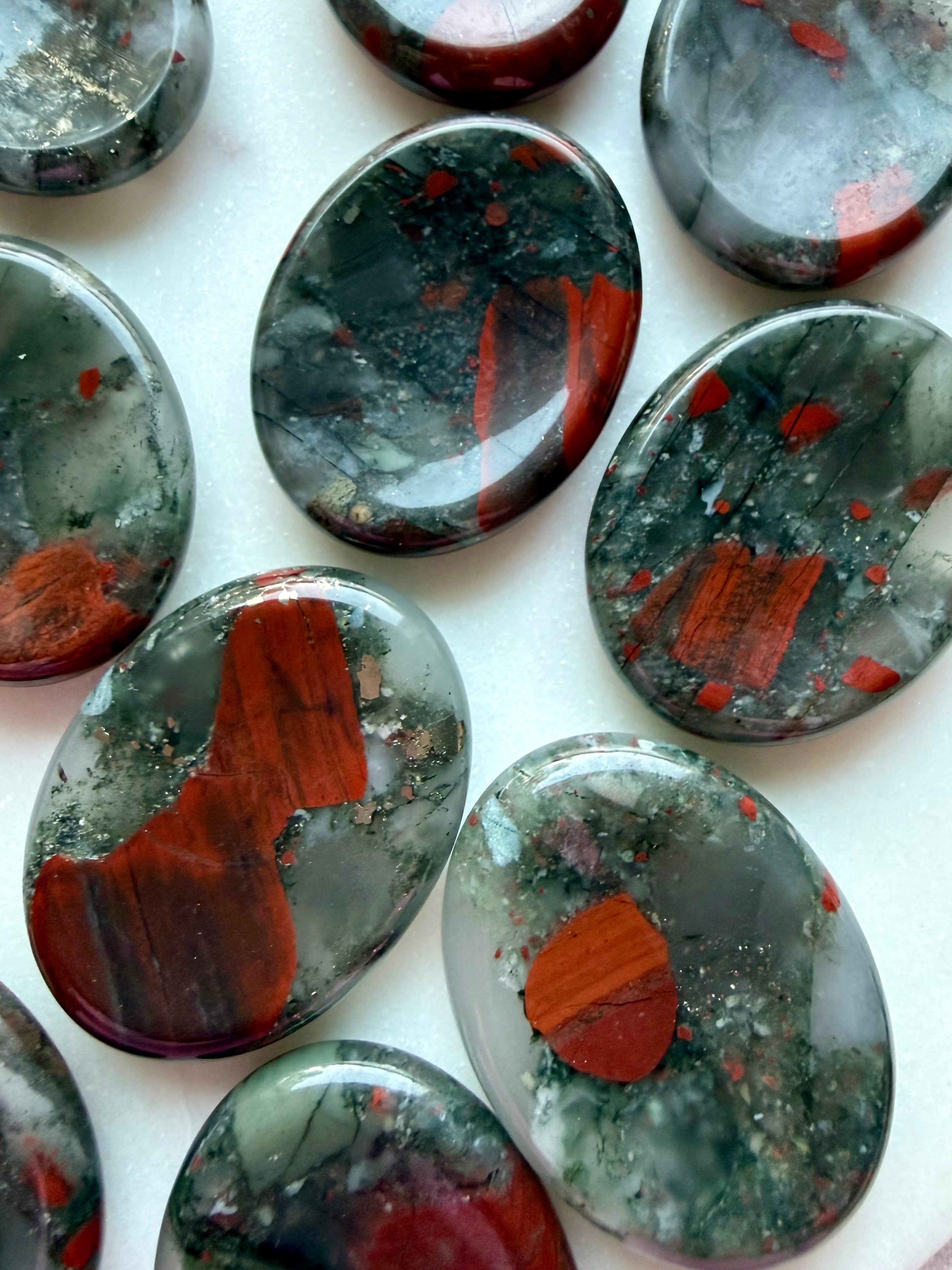 Natural Bloodstone thumb stones with distinctive red mineral formations and forest green coloring, grounding crystals for emotional balance