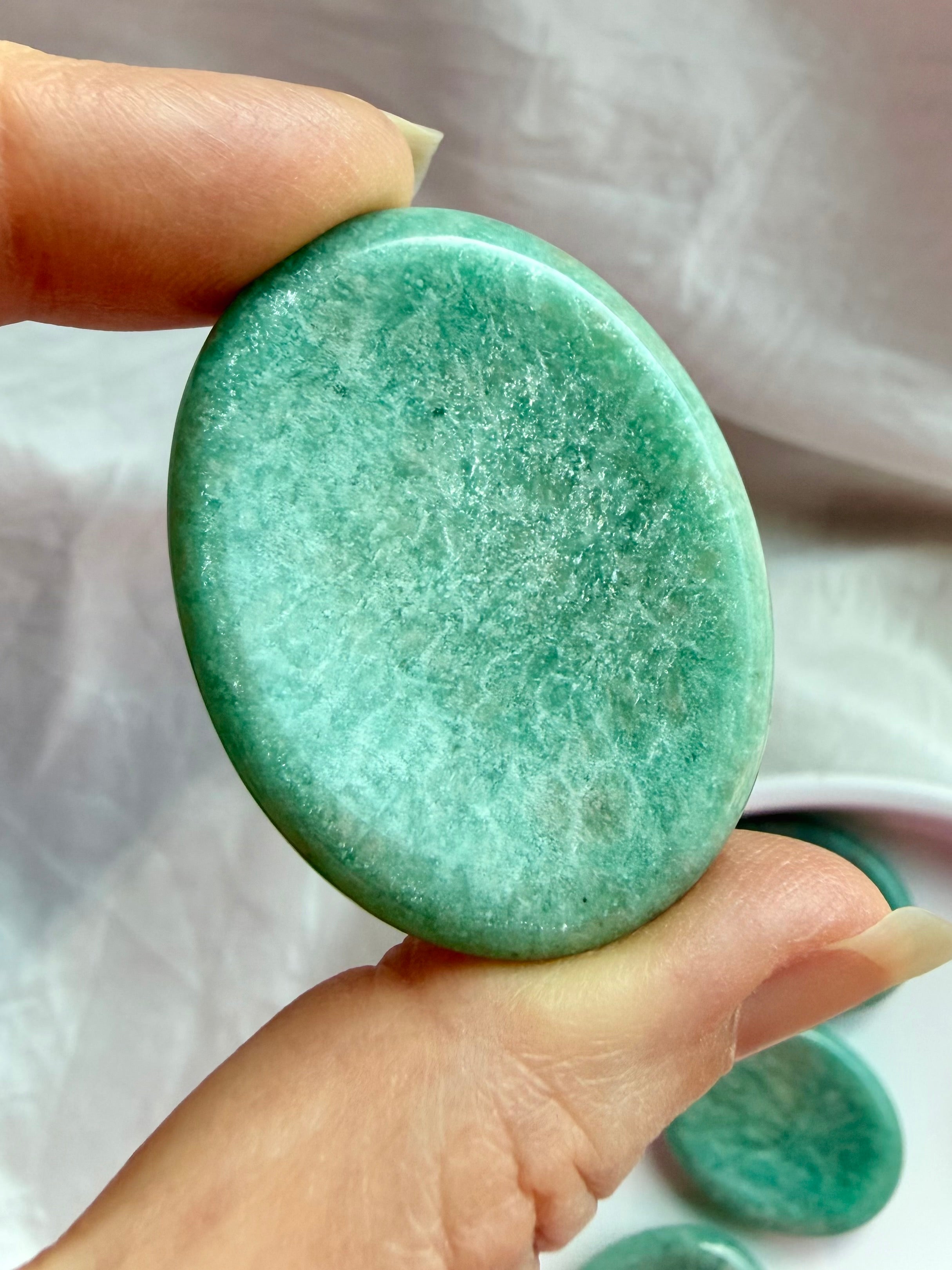 Close-up of Amazonite thumb stone revealing vibrant seafoam-green tones, natural mineral patterns and a gently curved thumb indentation
