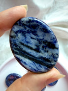 Natural Sodalite worry stone with swirling blue and white mineral patterns, Throat Chakra crystal for authentic self-expression