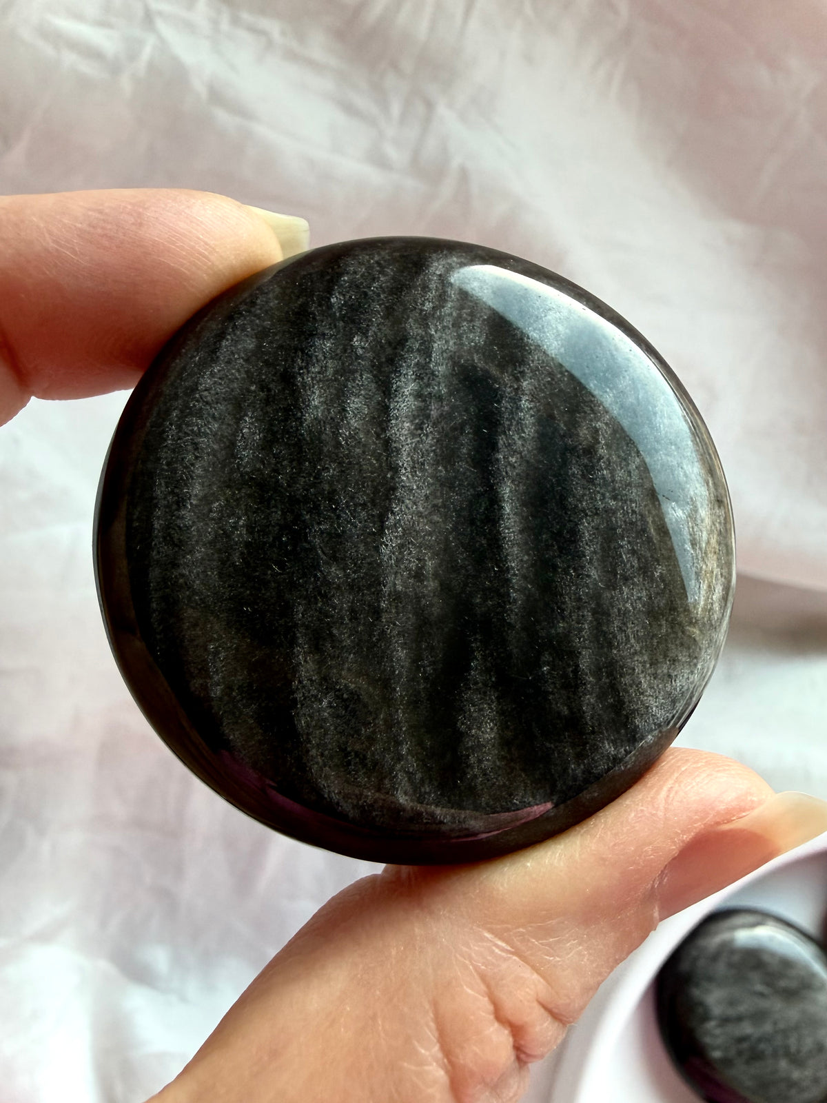 Round Silver Sheen Obsidian palm stone showing natural metallic shimmer and smooth polished edges
