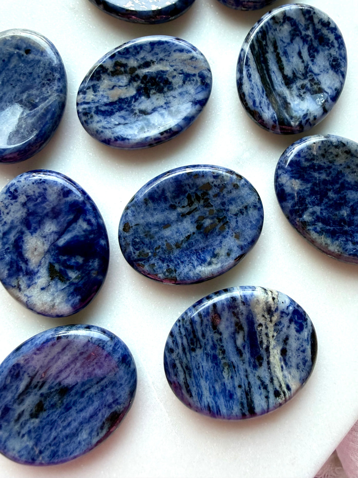 Sodalite thumb stones displayed together showing unique blue and white marbling, calming pocket crystals for everyday use