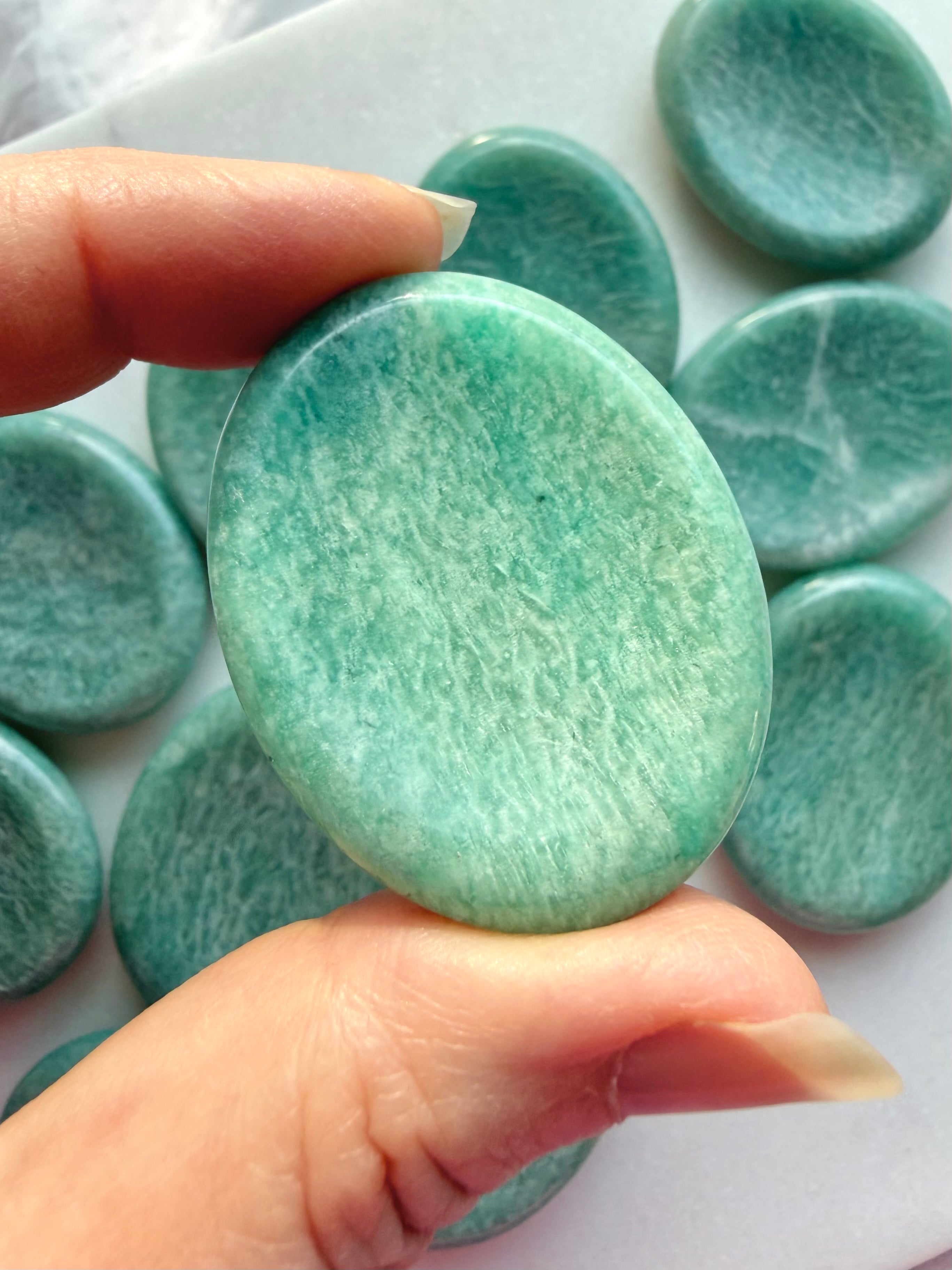 Amazonite worry stone shown close-up with natural color variations and smooth polished thumb indentation for calming meditation rituals