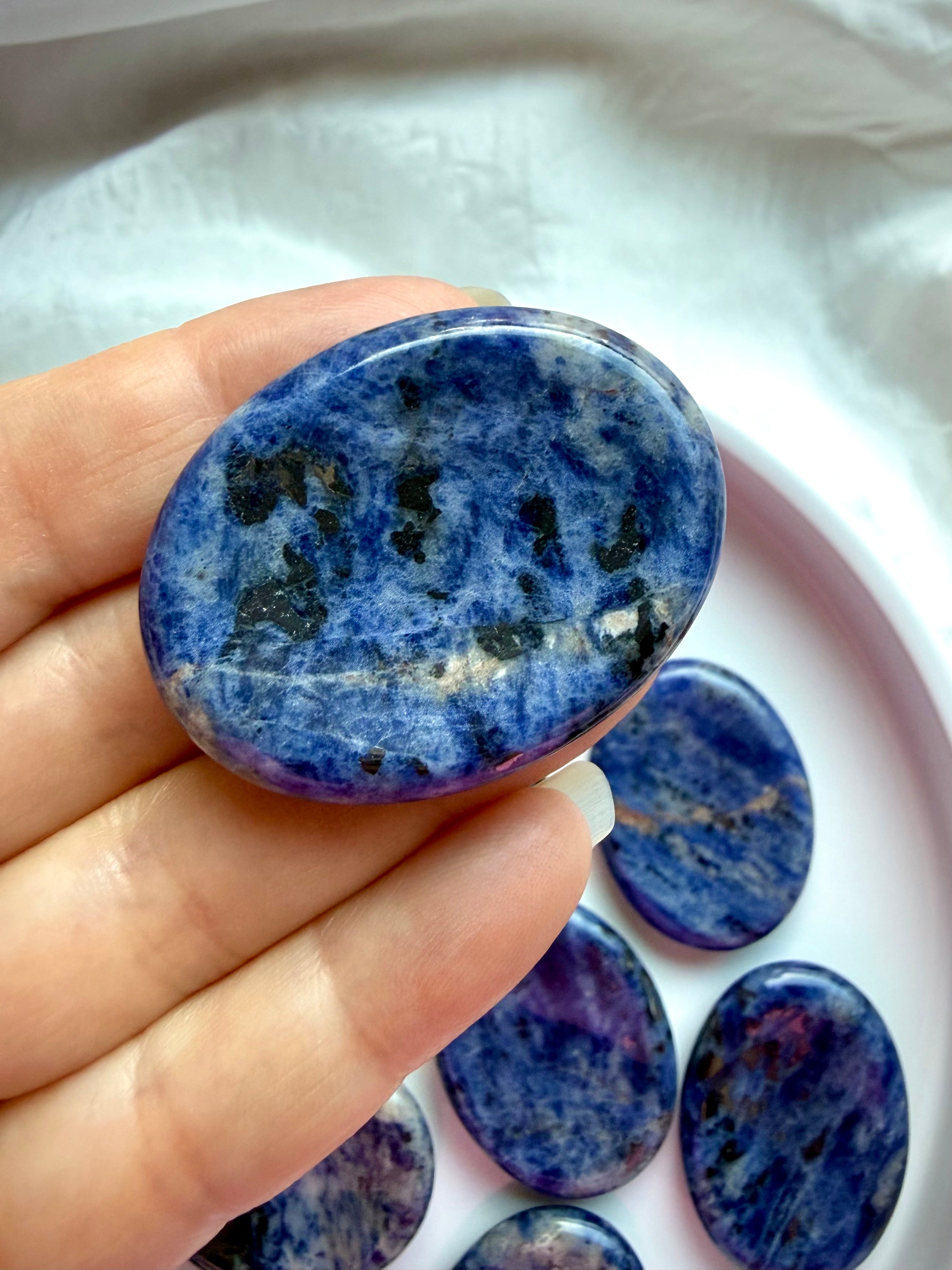 Close-up of polished blue Sodalite worry stone showing natural veining and glossy finish, crystal for intuition and mental clarity