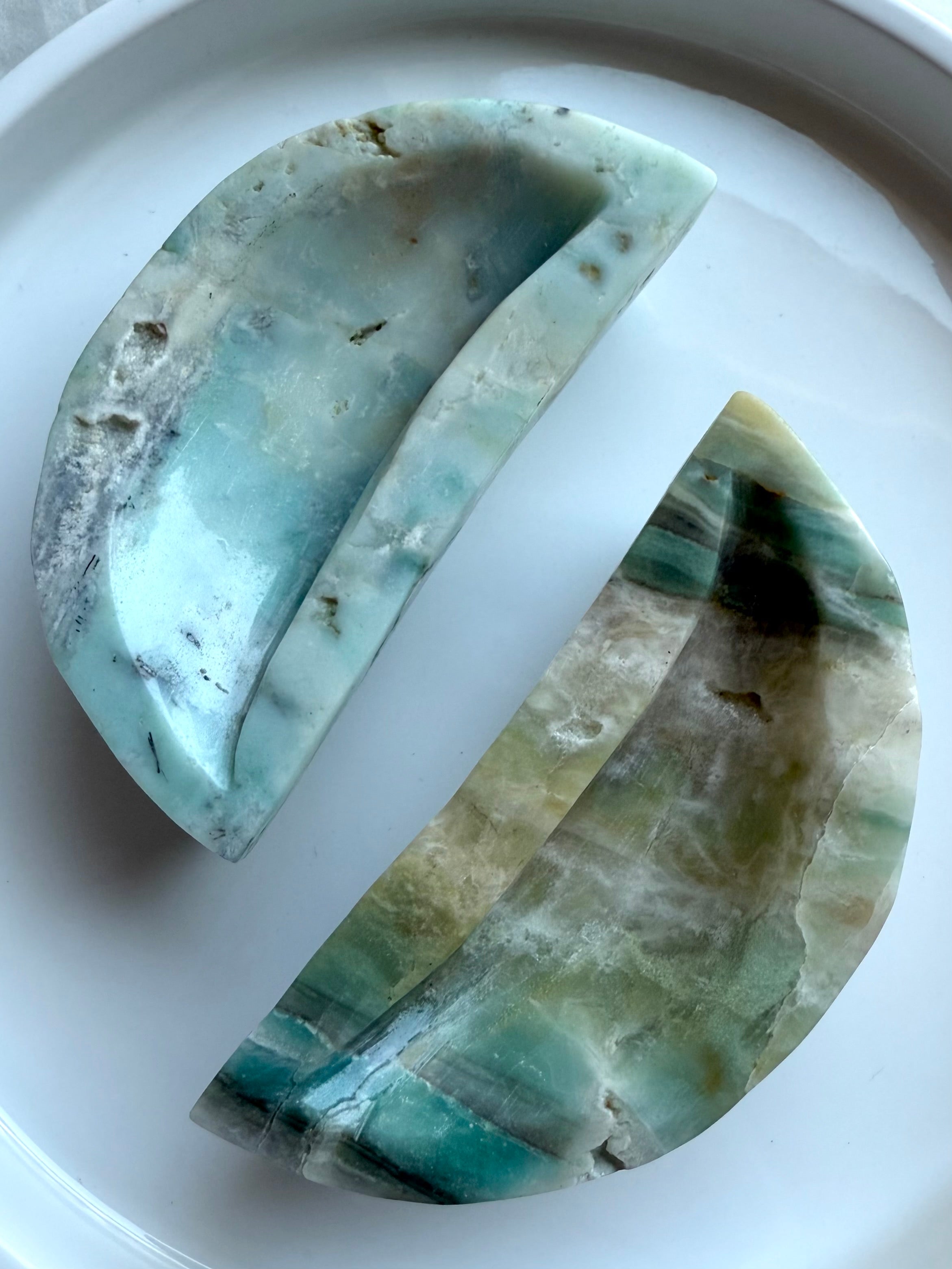 Closeup of Sky Blue Quartz crescent moon bowl – polished gemstone dish with blue, green, and earthy tones