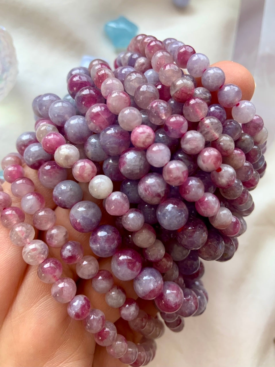 Side view of stacked Unicorn Stone bracelets in varying bead sizes — beaded crystal jewelry with Pink Tourmaline in Lepidolite for emotional balance + gentle energy.