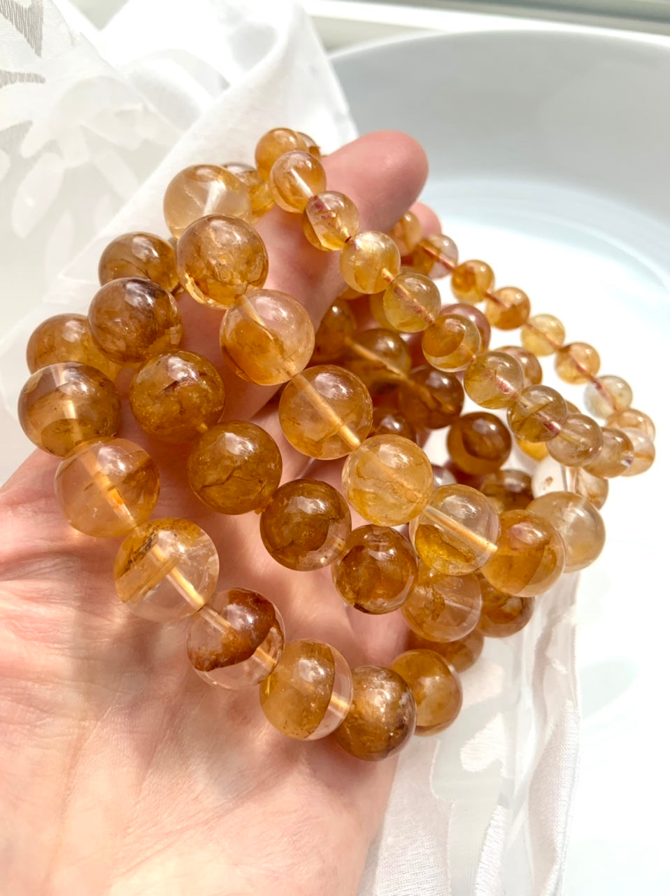 Golden Healer Quartz bracelets held to the light, showing high quality clarity and radiant yellow hematoid inclusions