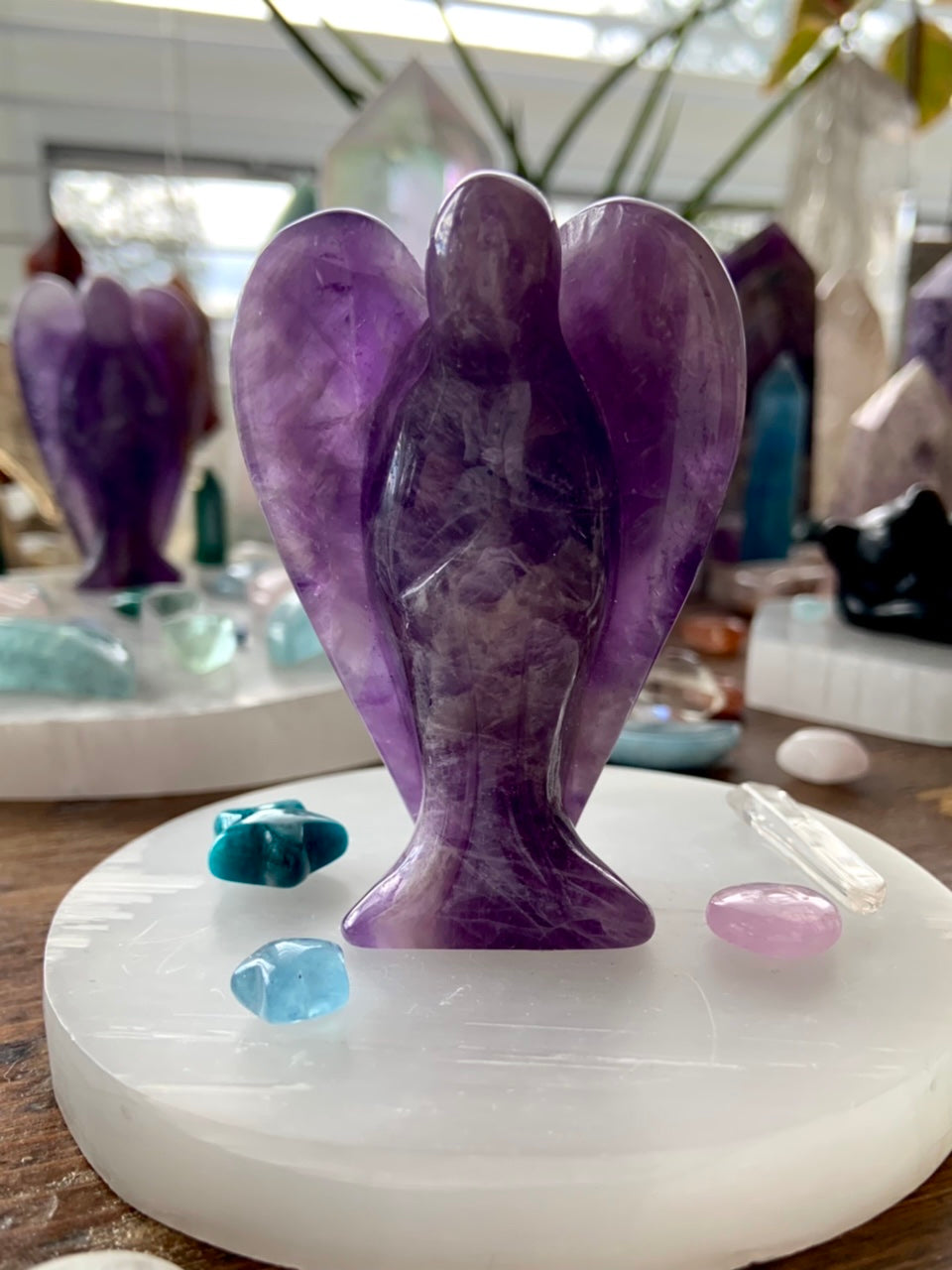 Selenite plate used as altar base for amethyst angel carving with mini celestial crystal accents
