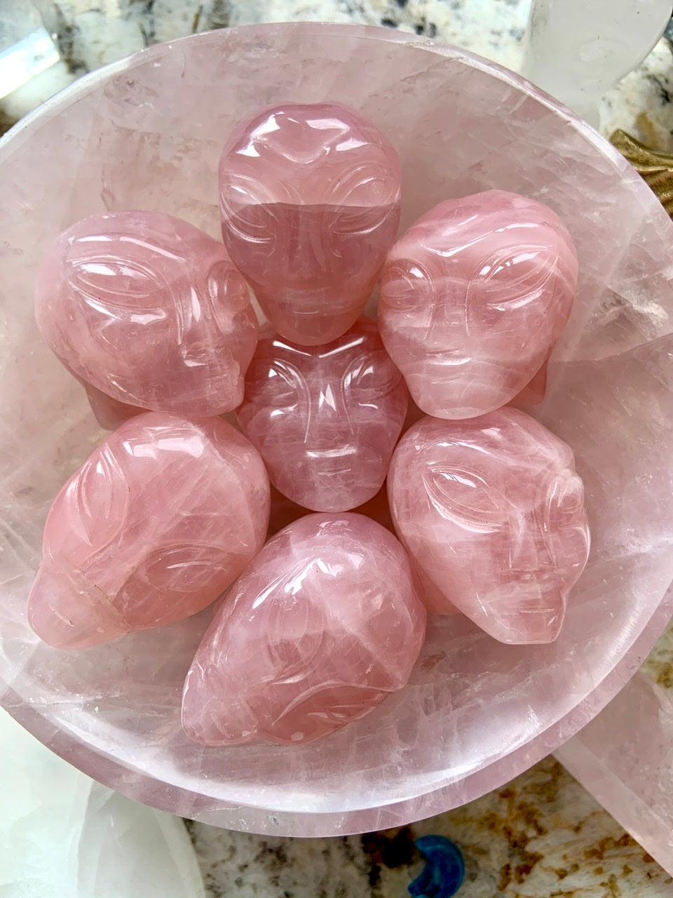 Group of Rose Quartz alien head carvings in matching crystal bowl – metaphysical crystal art for love, healing + higher realms