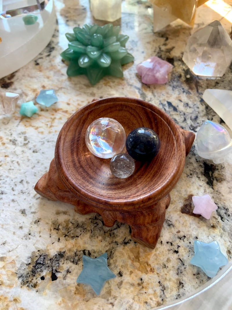 a wooden dish holding a collection of mini crystal spheres