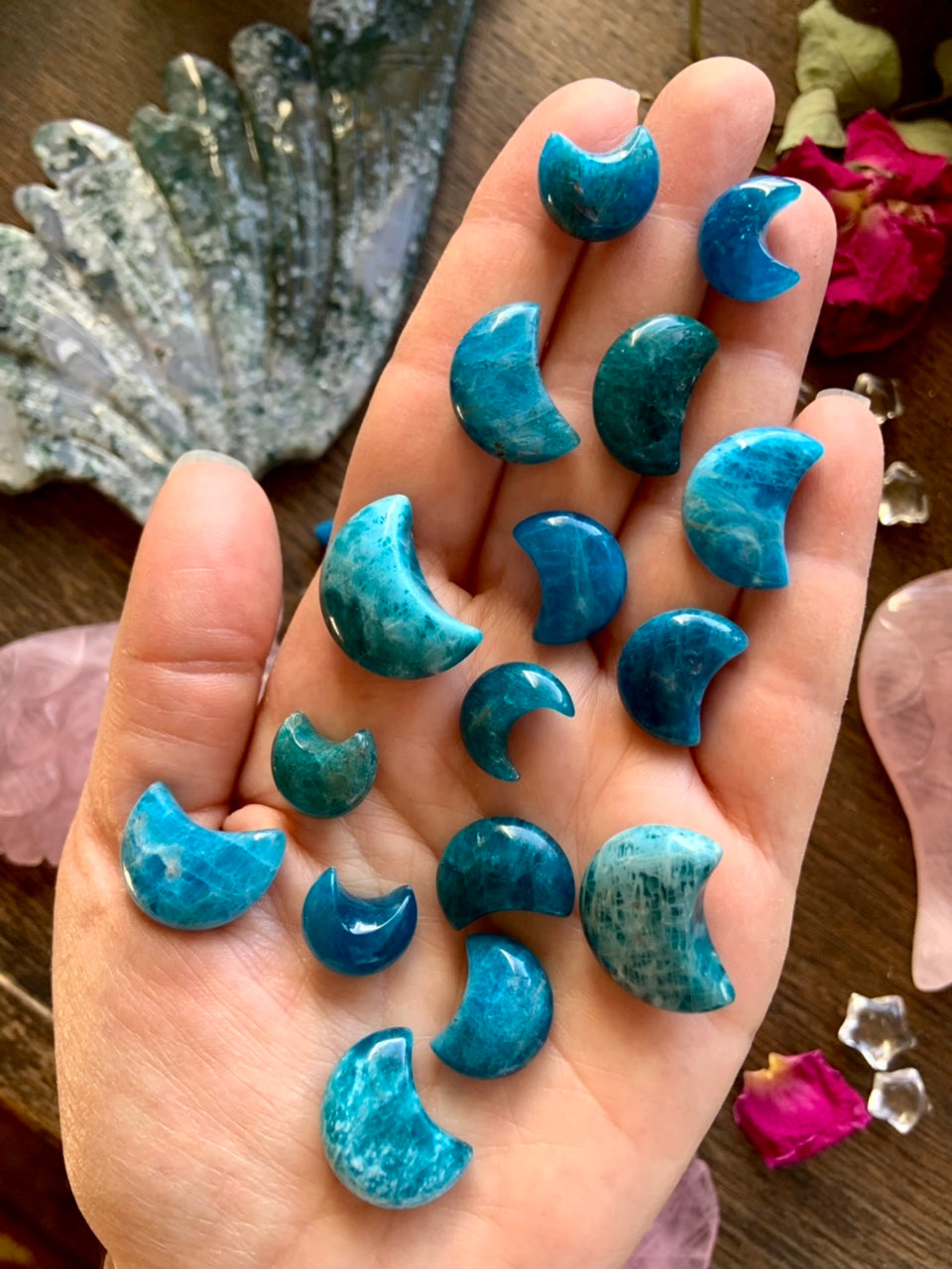Blue Apatite Crescent Moons shown in hand — mini teal crystal moon carvings for Throat Chakra healing, clarity & inspired communication.