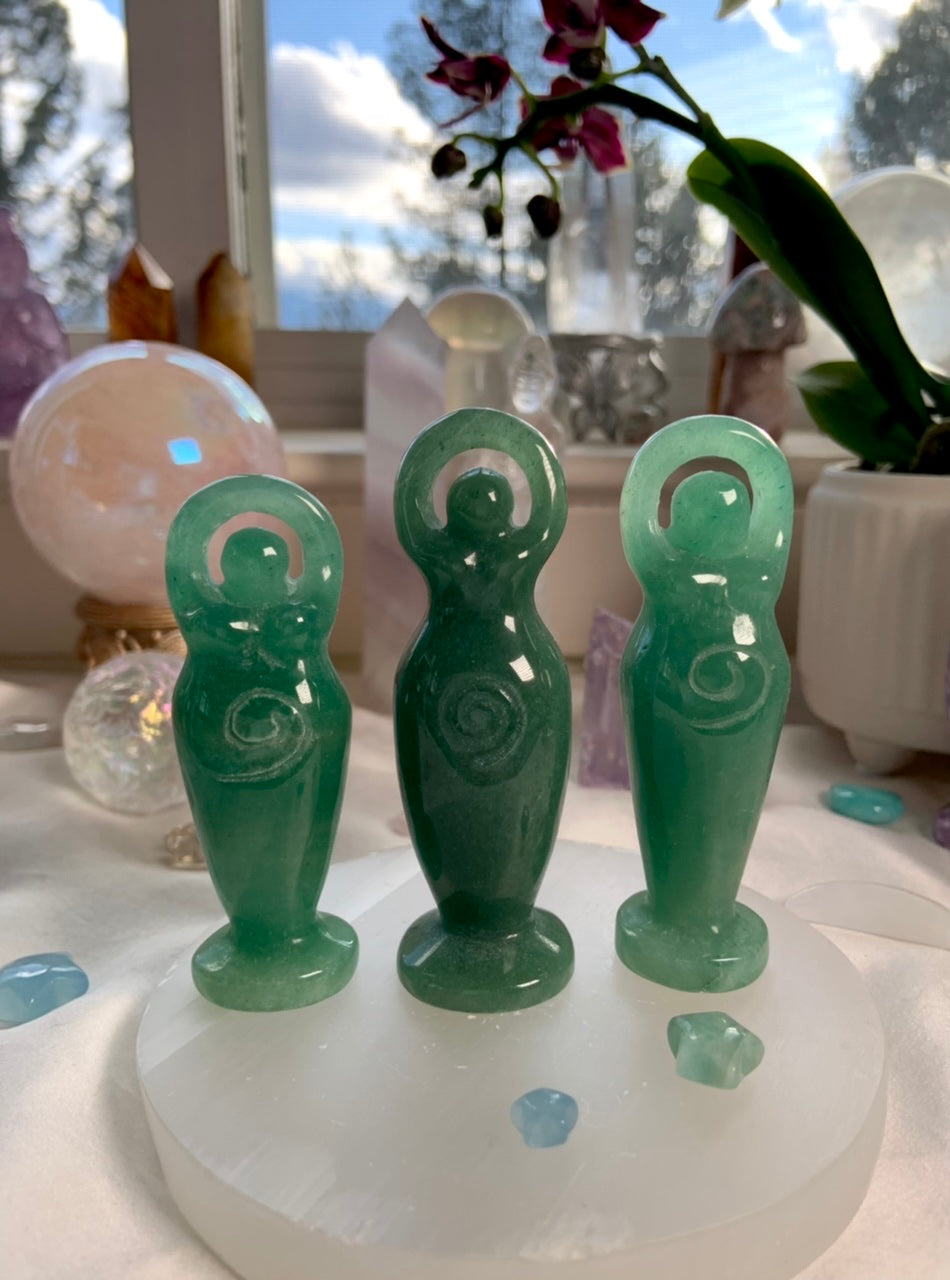 Green aventurine crystal goddess statues on a selenite plate shown in a crystal collection
