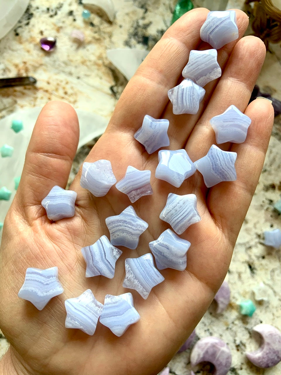 Mini Blue Lace Agate stars on hand for scale — soothing crystals for communication, clarity & emotional healing