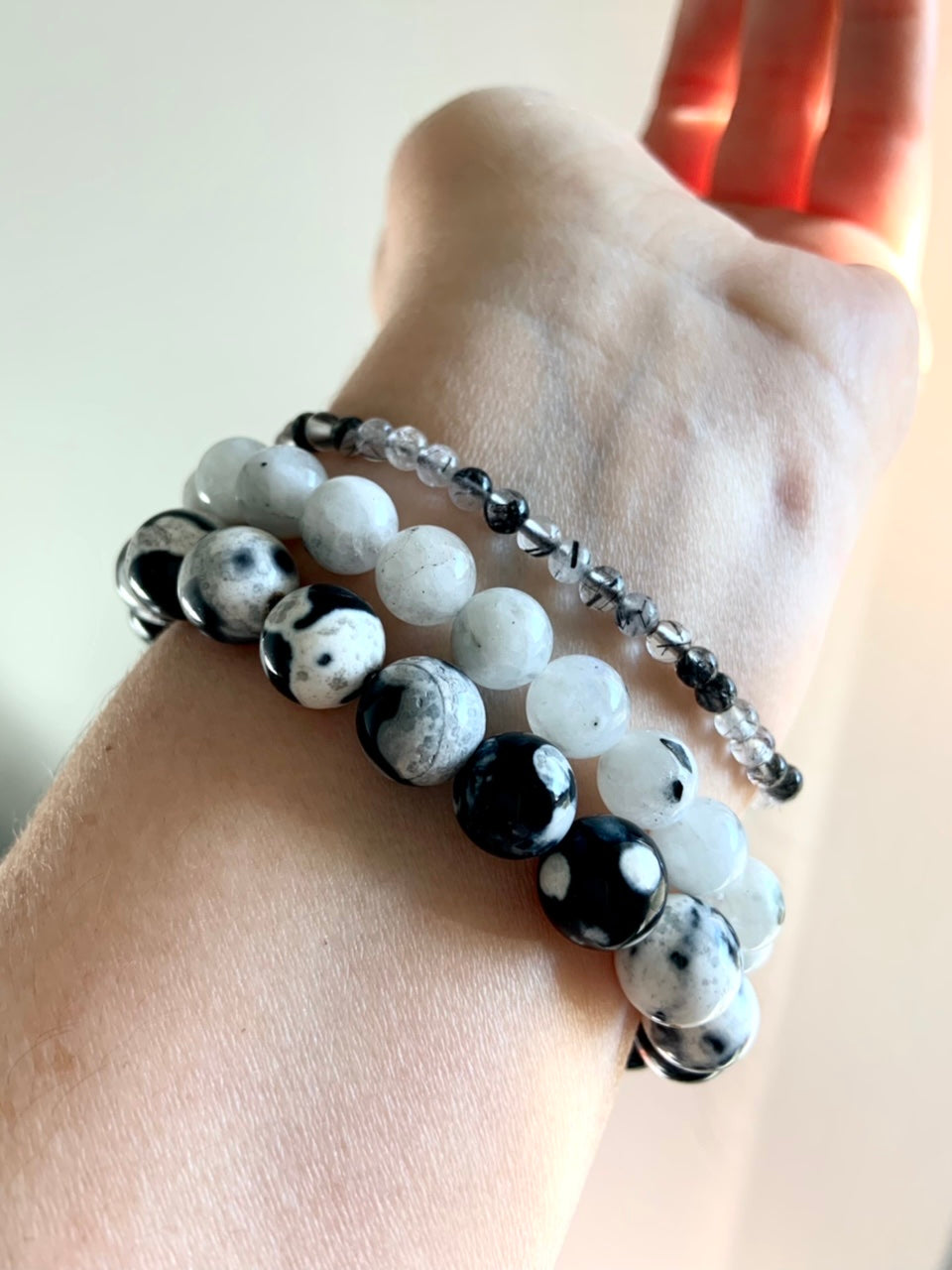 Mixed bracelet stack featuring 10–11mm Orca Agate beads paired with Rainbow Moonstone and Black Tourmaline in Quartz crystal bracelets