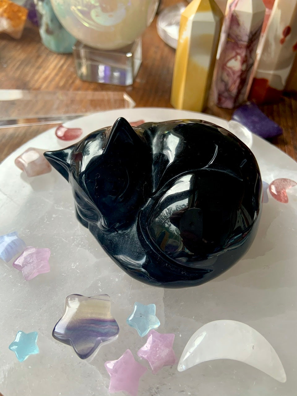 Angled view of Obsidian sleeping cat carving with selenite plate & pastel crystals — spiritual décor & heartfelt gift for cat lovers.