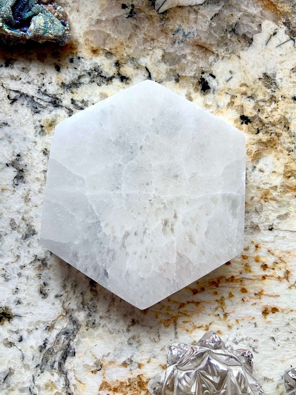 Overhead view of Selenite Hexagon Charging Plate on granite background for altar or chakra energy cleansing