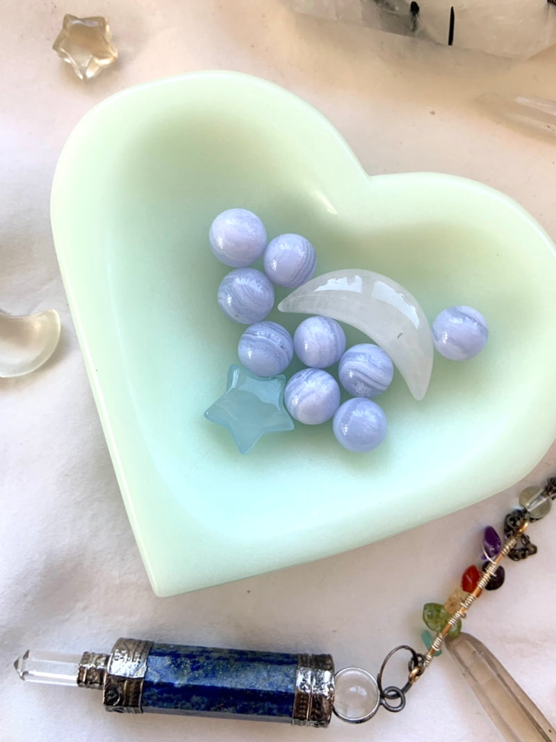 tiny blue lace agate spheres shown in a heart shaped bowl with other mini crystals