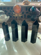 An array of black obsidian points shown in a group on top of a selenite plate 