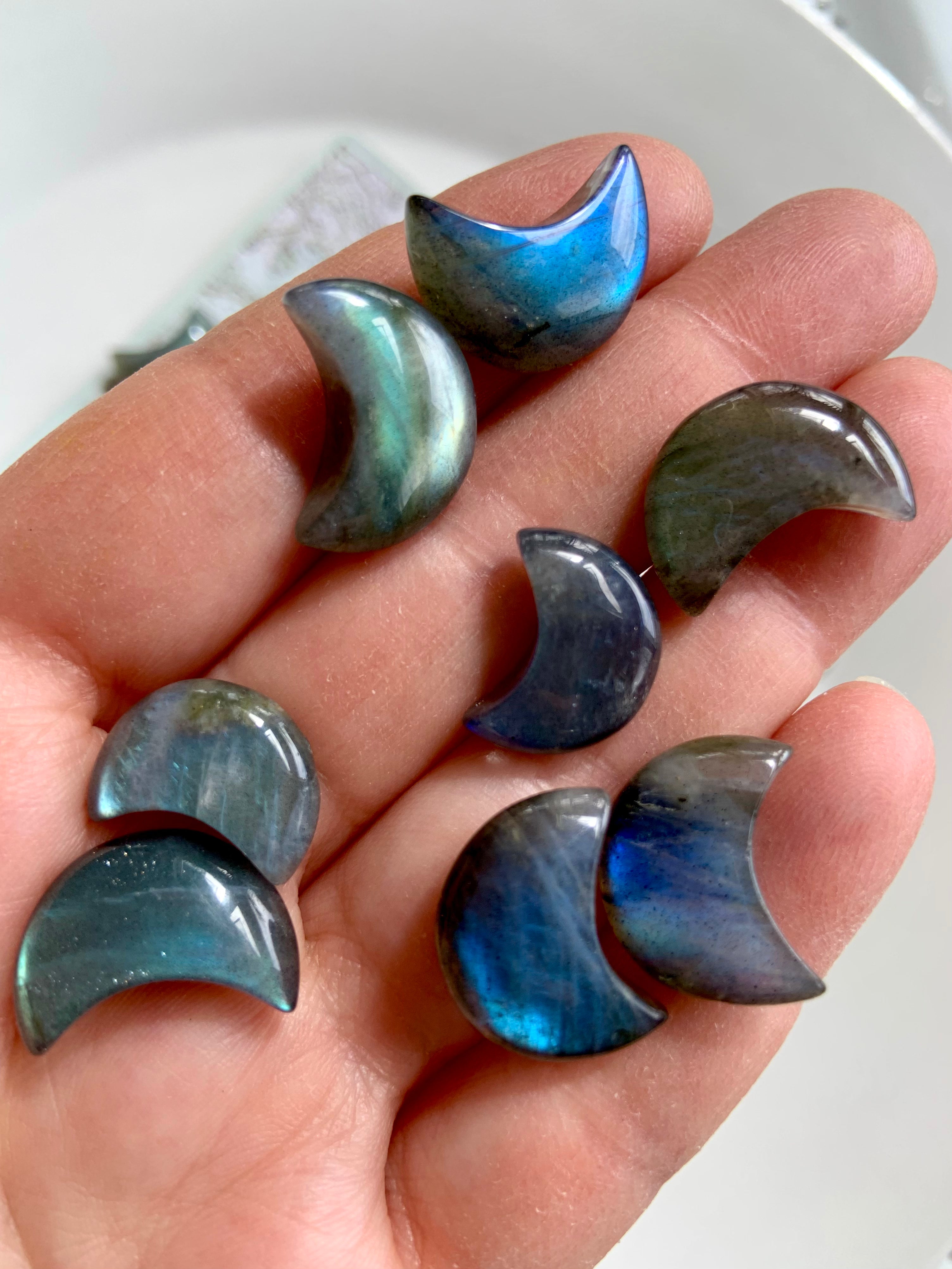 Mini Labradorite moon shown on fingertips for scale — iridescent crystal carving for spiritual awareness, clarity & mystical energy.